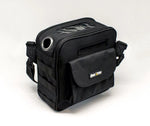 Black rectangular carrying case with front pocket, shoulder strap, clear top window, and metal ventilation ring.