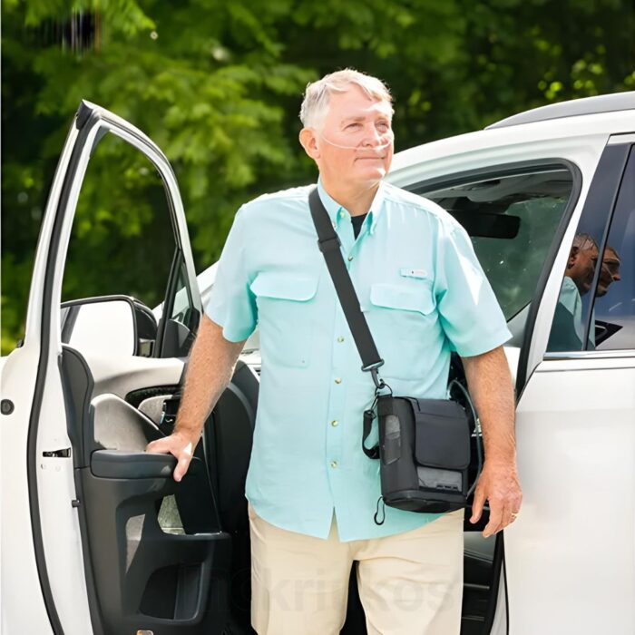 Man standing by open car door wearing a light blue shirt and carrying a black shoulder case.