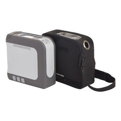 Compact gray and white portable oxygen concentrator with black carrying case and shoulder strap.