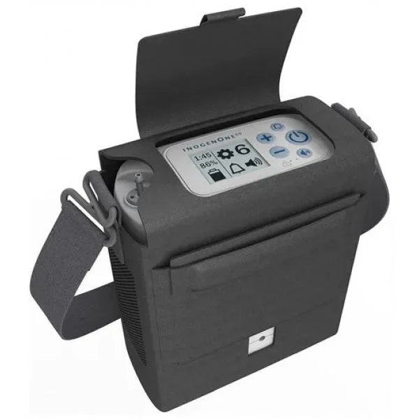 Compact black portable oxygen concentrator with carrying strap and digital control panel under flap cover.