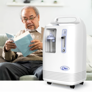 White and blue Olive 10L oxygen concentrator with handle, flowmeter, and humidifier bottle on table.